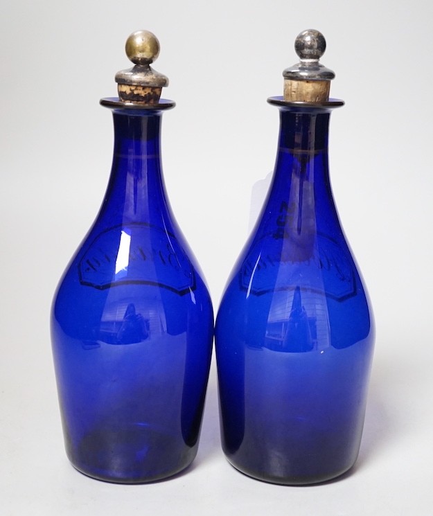 A pair of Regency blue glass decanters, labelled in gilt; Brandy and Hollands, 19cms high not including stoppers